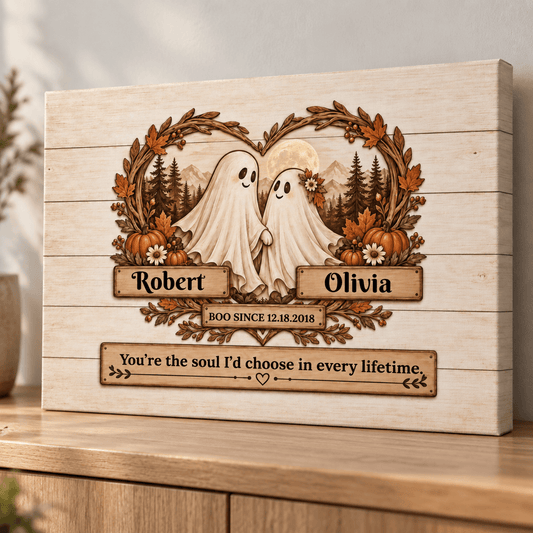 Personalized wooden Halloween wall art featuring two ghost figures inside a wreath with pumpkins, mountains, and trees, with custom names Robert and Olivia and a quote below, shown on a wooden surface.