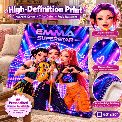 A colorful custom fleece blanket featuring three cartoon-style female singers with the text 'EMMA SUPERSTAR' on a couch in a living room. The image includes promotional callouts showing close-ups of the printed face art, vibrant colors, detailed stitching, and size information.