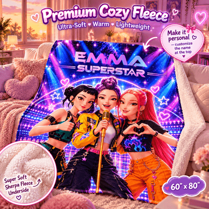 A fleece throw blanket draped over a couch in a living room setting, featuring a colorful printed design of three cartoon-style girls with the text 'EMMA SUPERSTAR' and heart graphics. The image includes promotional text overlays highlighting the blanket's soft, warm, and lightweight fleece material, along with customization options.