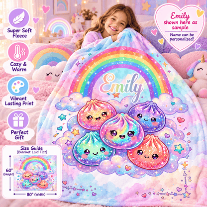 A child sits in a pastel bedroom holding a soft, colorful blanket featuring a rainbow, clouds, and cute pastel dumpling characters. The blanket has the name 'Emily' printed on it.