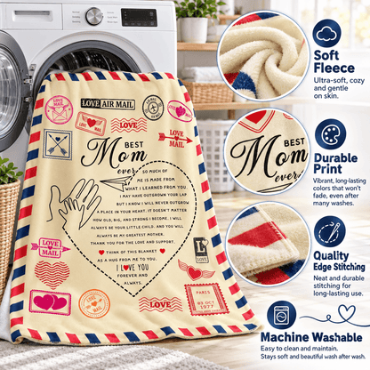 A fleece blanket with a vintage airmail-style envelope border and 'Best Mom Ever' text and heart design, shown in a laundry room setting next to a washing machine. The image includes three circular callout graphics highlighting the soft fleece texture, durable printed design, and neat edge stitching.