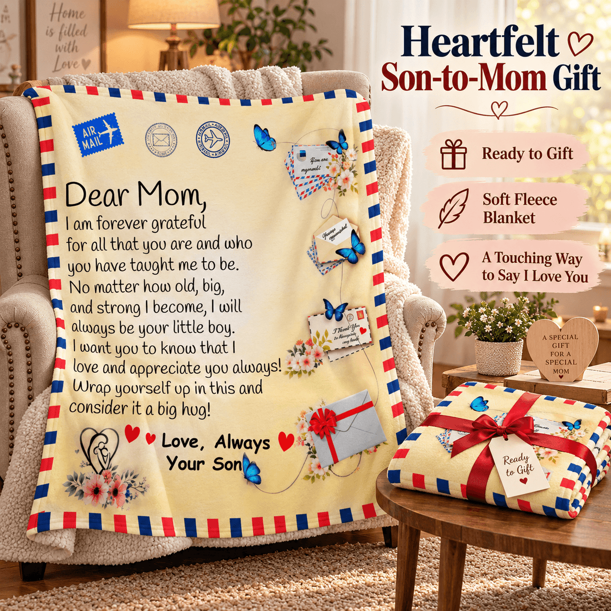A cream-colored fleece blanket with a red and blue striped border, printed with a heartfelt letter to Mom, butterflies, postmarks, and hearts. The blanket is draped over an armchair in a cozy living room setting, with a smaller folded version on a wooden table next to it.