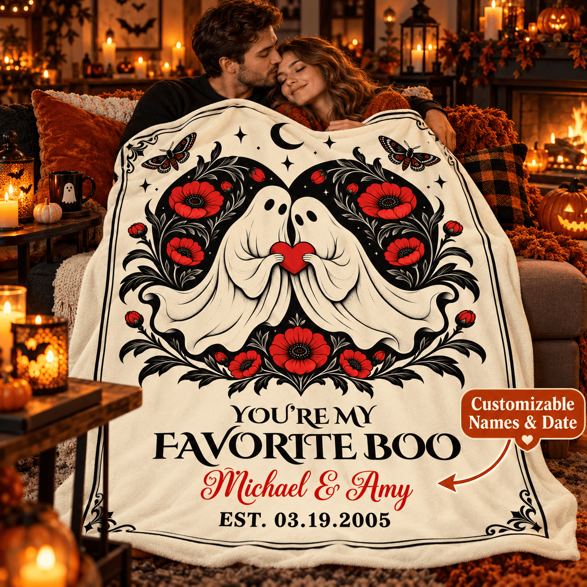 A couple hugging while wrapped in a large cream fleece blanket featuring a black and red gothic ghost illustration with flowers and the text 'YOU'RE MY FAVORITE BOO Michael & Amy EST. 03.