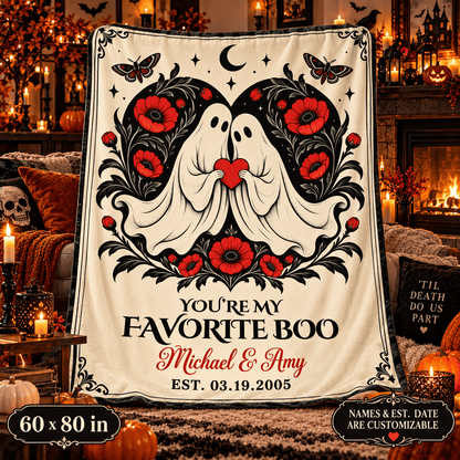 A large cream-colored blanket or throw with a Halloween-style graphic of two white ghosts surrounded by red flowers and black decorative details, with the text 'YOU'RE MY FAVORITE BOO Michael & Amy EST. 03.