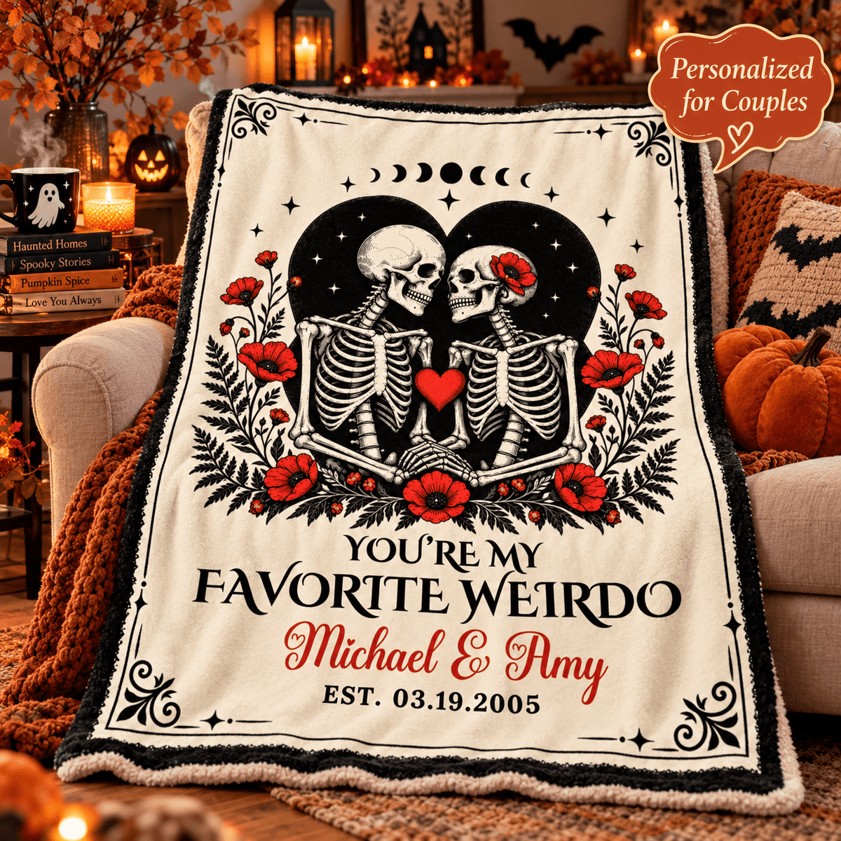 A personalized fleece throw blanket draped over a couch in a cozy Halloween-themed living room. The blanket features a cream background with a black and red graphic of two skeletons facing each other, surrounded by red poppies and black ornamental borders.